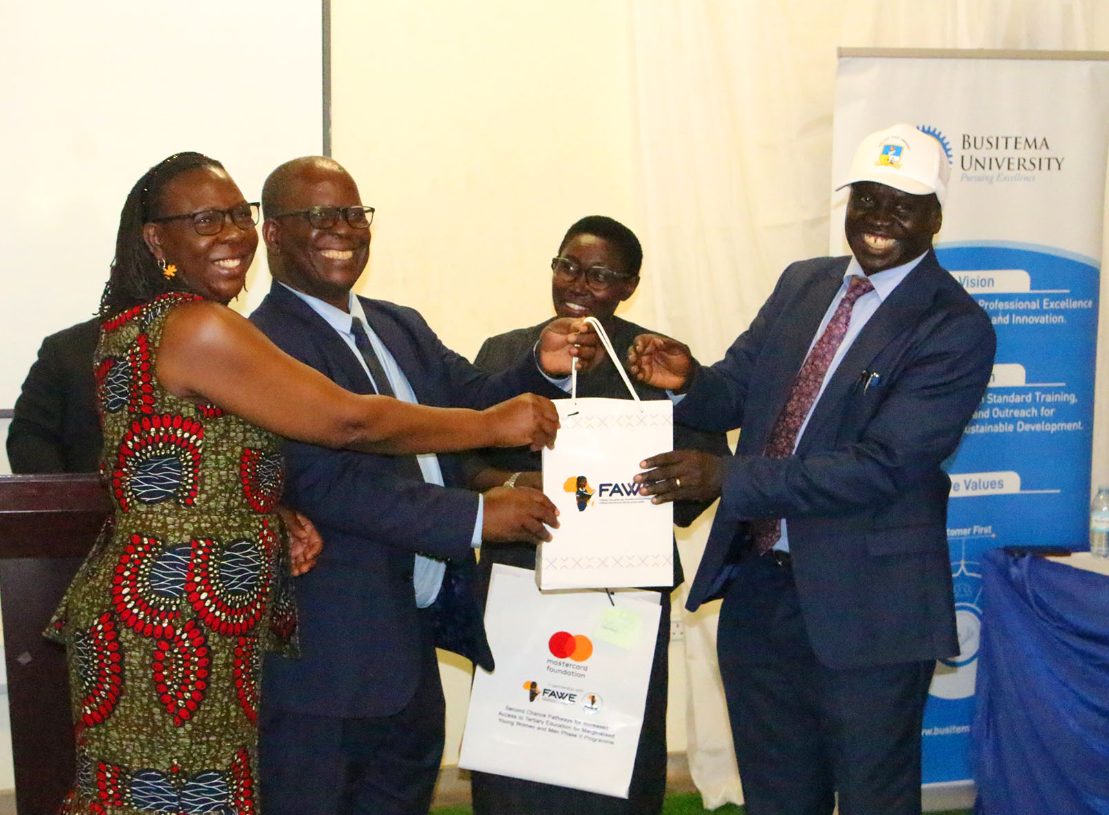 Prof. Paul Waako, receiving a gift from representatives of FAWE and Zimbabwe’s Ministry of Higher and Tertiary Education during the HEAP benchmarking visit
