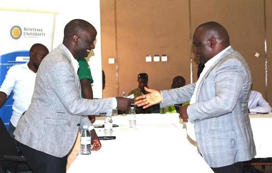 Dr. Charles Muweesi, Director of Institutional Advancement, engages with Eng. Maximo Twinomuhangi, Program Coordinator from the Ministry of Water & Environment, during the Youth Debate
