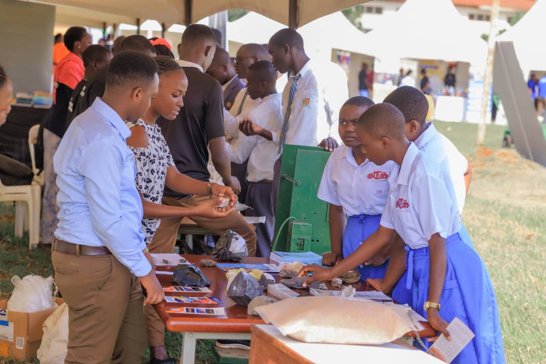 Students listen attentively to an exhibitor during a tour of the exhibition stalls